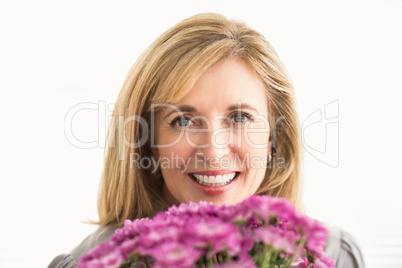 Smiling casual businesswoman holding flowers