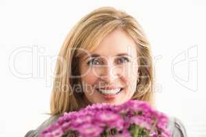 Smiling casual businesswoman holding flowers