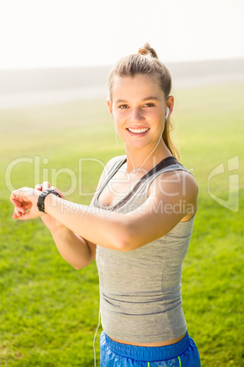 Smiling sporty blonde using smart watch