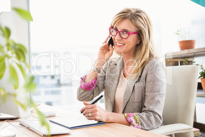 Smiling casual designer having a phone call