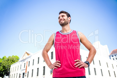 Smiling handsome athlete with hands on hips