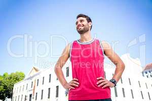 Smiling handsome athlete with hands on hips