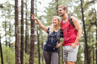 Happy young couple pointing at something