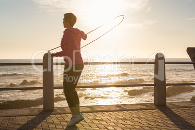 Sporty woman skipping at promenade