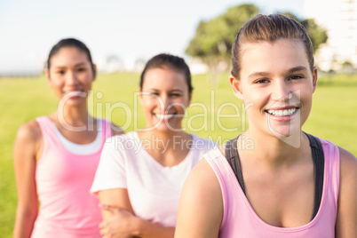 Three smiling women wearing pink for breast cancer