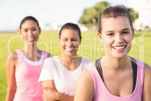 Three smiling women wearing pink for breast cancer