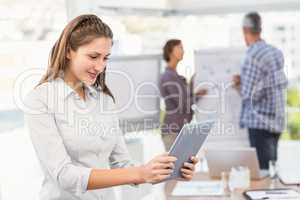 Smiling businesswoman using tablet in a meeting