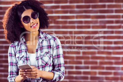 Attractive smiling hipster holding smartphone