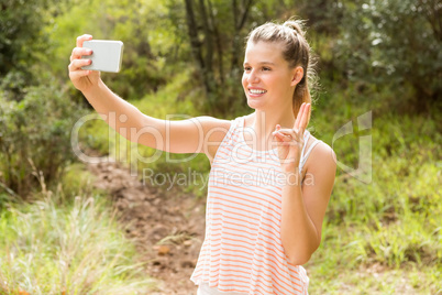 Pretty blonde showing peace sign and taking selfies