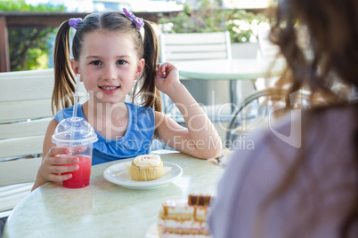 Mother and daughter enjoying cakes at cafe terrace