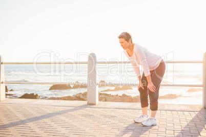 Breathing sporty woman resting at promenade