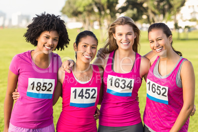 Four smiling runners supporting breast cancer marathon