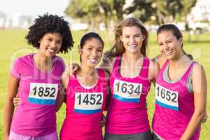 Four smiling runners supporting breast cancer marathon