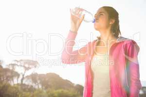 Fit woman drinking water from bottle