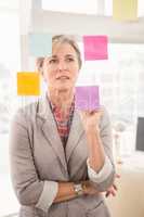 Casual businesswoman reading sticky notes