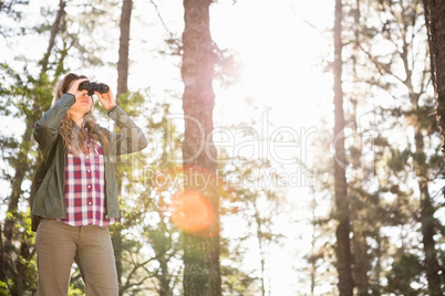 Blonde hiker looking through binoculars