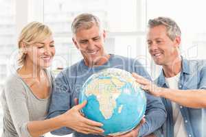 Happy business colleagues holding terrestrial globe