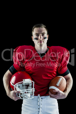American football player holding helmet