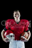 American football player holding helmet