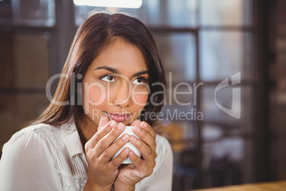 Beautiful woman drinking a coffee and looking away