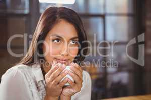 Beautiful woman drinking a coffee and looking away