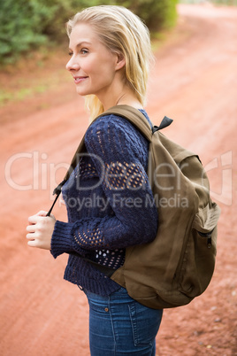 Smiling female hiker waiting by the side of the road