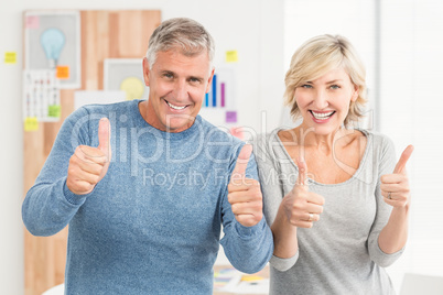 Smiling business team gesturing thumbs up