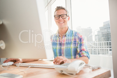 Smiling casual businessman working with computer