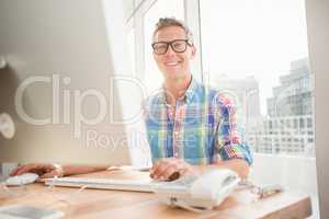 Smiling casual businessman working with computer