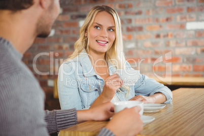 Smiling blonde having coffee with friend