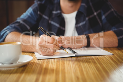 Young man taking notes in his notebook