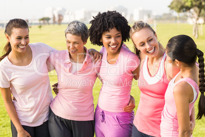 Laughing women wearing pink for breast cancer