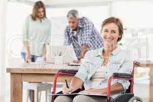 Casual businesswoman in wheelchair with notepad