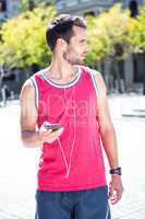 Handsome athlete sending a text