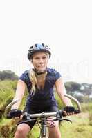 Focused athletic blonde mountain biking