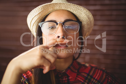 Beautiful hipster with mustache on finger