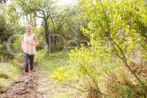 Blonde athlete jogging on trail