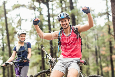 Young happy couple on bikes looking at camera