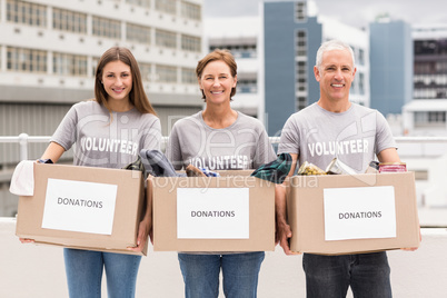 Smiling volunteers holding donation boxes