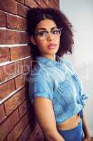 Attractive hipster leaning against red brick background