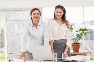 Smiling businesswomen using laptop