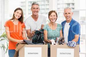 Smiling casual business people sorting donation boxes