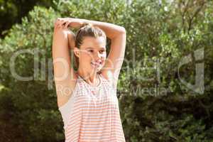 Smiling blonde athlete stretching arms