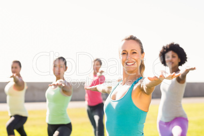 Smiling sporty blonde doing yoga in yoga class