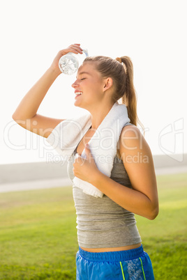 Sporty blonde cooling forehead with water bottle