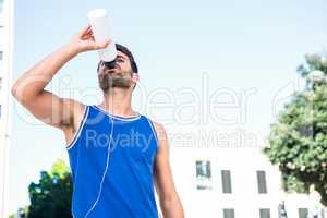 Handsome athlete drinking out of bottle