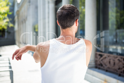 Rear view of athlete stretching his arm