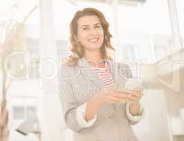 Smiling casual businesswoman holding smartphone