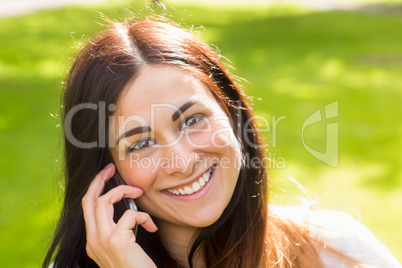 Beautiful brunette making a call in the park