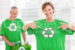 Smiling eco-minded woman showing her recycling shirt